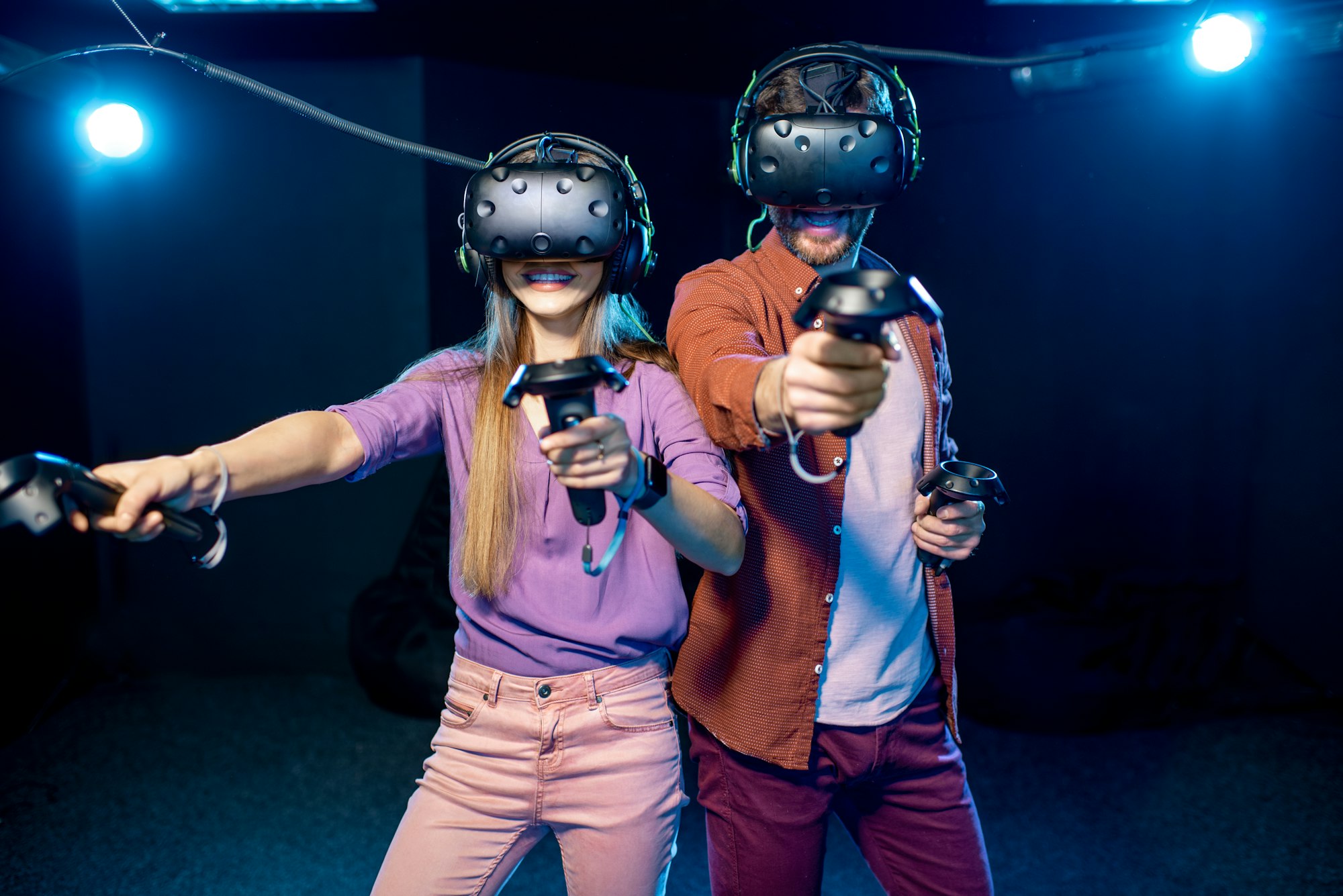 Man and woman playing game with virtual reality headset in the club